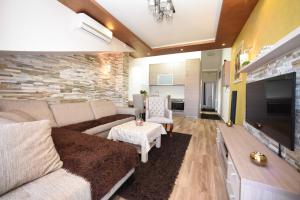 a living room with a couch and a tv at D&D Apartments in Tivat