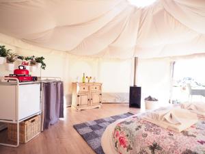 une chambre avec un lit et une tente dans l'établissement Old Dairy Farm Glamping, à Emsworth