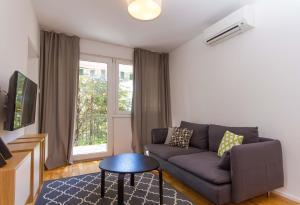 - un salon avec un canapé et une fenêtre dans l'établissement Forgotten Garden Apartments and Rooms, à Portorož