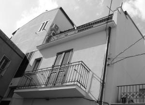 パラッツォーロ・アクレイデにあるAgorà-Akrai B&Bのバルコニー付きの建物の白黒写真