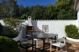 un patio con mesa, sillas y una valla en Quinta Falzina en Luz