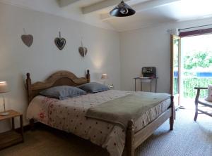 a bedroom with a large bed and a window at Gite du Carbounet et la Grange de Lou in Siguer