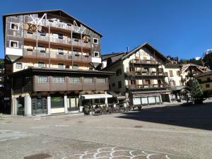 a large building with tables and chairs in front of it at Sport Campiglio Apartment in Madonna di Campiglio