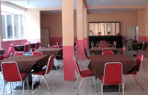 a room with tables and chairs in a building at Hotel Mitra Garden in Pangkalpinang