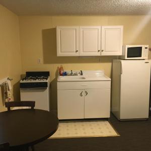 eine kleine Küche mit Spüle und Kühlschrank in der Unterkunft Clarence Inn Extended Stay in Clarence Center