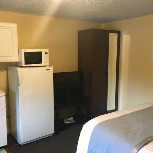 a room with a microwave on top of a refrigerator at Clarence Inn Extended Stay in Clarence Center
