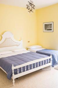 スペルロンガにあるCasa Ledaの黄色の壁とシャンデリアが特徴のベッドルーム1室(ベッド2台付)