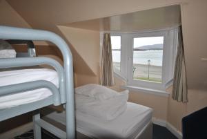 Cette petite chambre comprend des lits superposés et une fenêtre. dans l'établissement Saucy Mary's Hostel, à Kyleakin