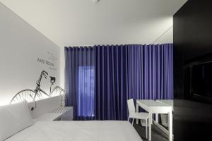 a room with a bed, a chair, and a window at Hotel 3K Europa in Lisbon