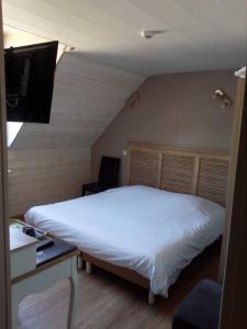 a bedroom with a large white bed and a desk at Chic'o Rail in Saint-Omer