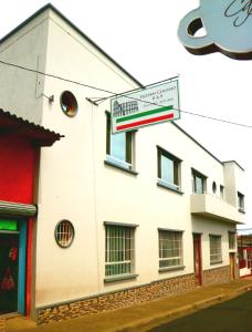 a white building with a sign on the side of it at Pizzeria Colisseo B & B in Jinotepe