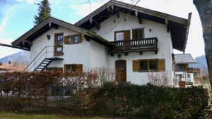 Casa blanca con balcón en la parte superior. en Apartment Kobellstrasse, en Rottach-Egern