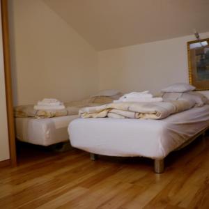 two beds sitting in a room with wooden floors at Apartment Kobellstrasse in Rottach-Egern
