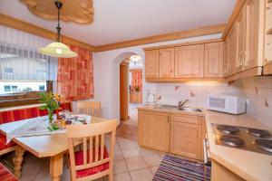 a kitchen with a table and a dining room at Unterbergbauer in Krimml