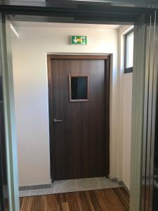 a brown door in a hallway with a window at Residence Kalliste in Ajaccio