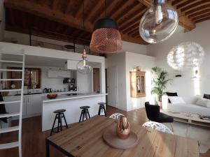 a kitchen and a living room with a table and chairs at La "Pépite" Du Vieux Lyon in Lyon