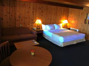 una camera d'albergo con letto, divano e tavoli di Prospector Motor Lodge a Blanding