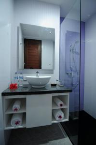 a bathroom with a sink and a mirror and a shower at Melasa House in Senggigi 