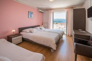 a bedroom with two beds and a large window at B&B Villa Ana in Krk