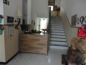 a lobby with a staircase with a desk and a stair case at Aimores Palace Hotel in Aimorés