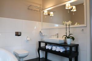 a bathroom with a sink and a toilet and a mirror at Hotel Villa Casino in Słubice