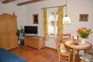 a living room with a table and a television at Hotel Gerberhaus in Rothenburg ob der Tauber