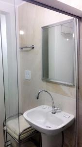 baño con lavabo, espejo y silla en Rua Dr Diogo de Faria,671 apto 85, en São Paulo