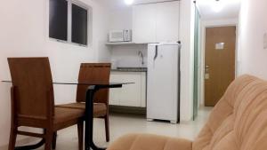 cocina con mesa, sillas y nevera en Rua Dr Diogo de Faria,671 apto 85, en São Paulo