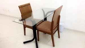 una mesa de cristal con una silla de madera y una mesa de cristal con una silla de cristal. en Rua Dr Diogo de Faria,671 apto 85, en São Paulo