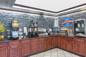 a coffee shop with wooden cabinets and a counter at Baymont by Wyndham Jonesboro in Jonesboro