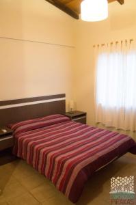 a bedroom with a bed with a striped blanket at Piraka´s in Gualeguaychú