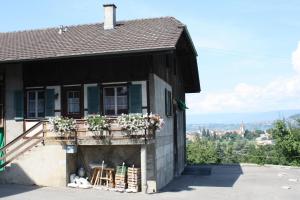 ein Haus mit einem Balkon mit Blumen darauf in der Unterkunft Hof Oberprehl in Murten