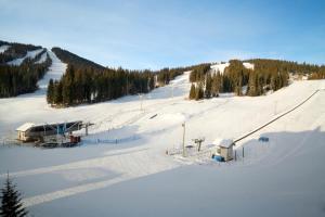 a snow covered ski slope with a ski lift at Sundance Lodge in Sun Peaks