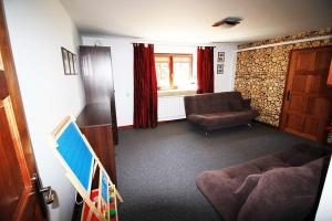 una sala de estar con un sofá y una silla en Poronin Apartament, en Poronin