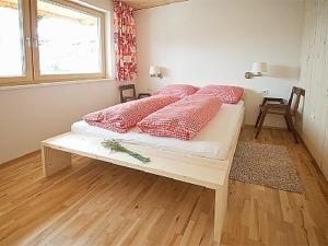 シュヴァルツェンベルク・イム・ブレゲンツァーヴァルトにあるFerienwohnung "Angelikahohe"のベッドルーム1室(ピンクの枕が付いたベッド1台付)