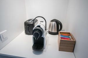 einen Tisch mit einer Kaffeemaschine, einem Toaster und einer Schachtel in der Unterkunft Studio Couleur Soleil in Roquebrune-Cap-Martin