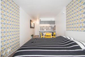a bedroom with a black and white striped bed at Studio Couleur Soleil in Roquebrune-Cap-Martin