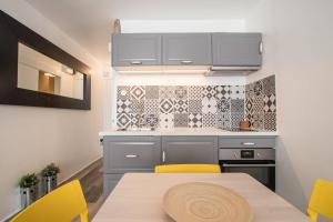 a kitchen with a table and yellow chairs at Studio Couleur Soleil in Roquebrune-Cap-Martin