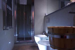 a bathroom with a large wooden tub next to a toilet at Relais CastelBigozzi in Monteriggioni