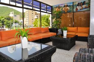 a lobby with orange couches and a table and chairs at Hotel Yuldama Rodadero Inn in Santa Marta