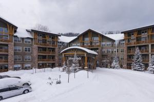 a snow covered parking lot in front of a large building at Silver Rock by FantasticStay in Fernie