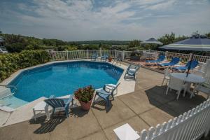 a swimming pool with chairs and a table and a table and chairs at Glen Cove Inn & Suites Rockport in Rockport