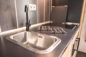 a stainless steel sink in a kitchen with a stove at Studio Mezzanine Bleu in Roquebrune-Cap-Martin