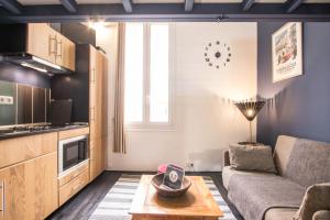 ein Wohnzimmer mit Couch und Tisch in der Unterkunft Studio Mezzanine Bleu in Roquebrune-Cap-Martin + 18 Fotos
