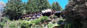 a house on a hill with a train on it at Dos Bahias Lake Resort in Villa La Angostura