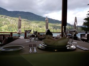 a table with plates and wine glasses on top of it at Dos Bahias Lake Resort in Villa La Angostura