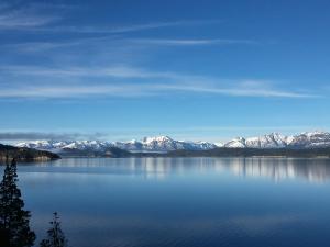 a view of a large body of water with snow covered mountains at Dos Bahias Lake Resort in Villa La Angostura