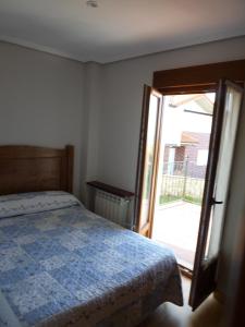 a bedroom with a bed and a sliding glass door at Apartamentos La Fuente de Enmedio in Suances +21 photos
