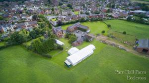 a large green field with a large building at Parr Hall Farm in Chorley