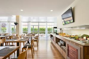 a restaurant with tables and chairs and a buffet at Nura Santa Ponsa & Spa in Santa Ponsa